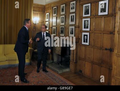 Premierminister David Cameron (links) und der französische Präsident Francois Hollande betrachten eine Fotowand, die ehemalige britische Premierminister nach Gesprächen in Chequers in der Nähe von Wendover zeigt. Stockfoto