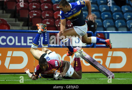 Huddersfield Giants Jermaine McGillvary versucht beim ersten Super-League-Super-8-Match im John Smiths Stadium, Huddersfield, gegen die Leeds Rhinos Zak Hardaker und Ryan Hall (rechts). Stockfoto