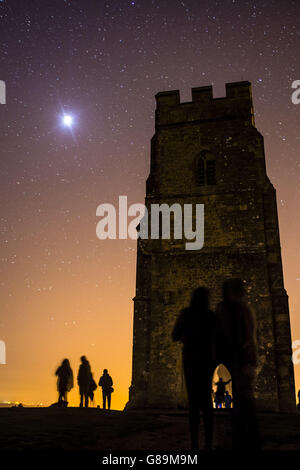 Die Menschen beobachten den Supermond vom Gipfel des Glastonbury Tor aus, kurz bevor der Erdschatten den hellen Mond vollständig bedeckt und eine totale Finsternis erzeugt. Stockfoto