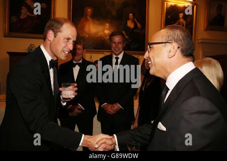 Der Duke of Cambridge spricht mit Gästen wie Theo Paphitis während des Tusk Trust Conservation Charity 25th Anniversary Ball im Syon House, Brentford, der die Wirkung der Charity inmitten der anhaltenden Krise würdigt, mit der sich die Tierwelt in Afrika konfrontiert sieht. Stockfoto