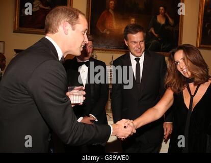 Der Duke of Cambridge spricht mit Gästen wie Peter Jones und Frau Tara während des 25-jährigen Jubiläums-Balls der Tusk Trust-Naturschutzorganisation im Syon House, Brentford, der den Einfluss der Stiftung inmitten der anhaltenden Krise der Tierwelt in Afrika würdigt. Stockfoto