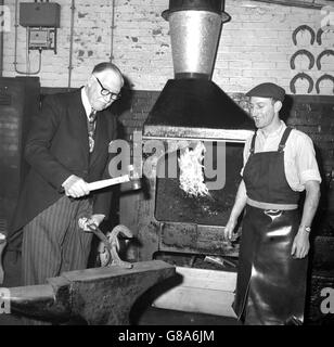 Sir Lionel Denny, Londons Oberbürgermeister, formt unter den zustimmenden Augen von Joe Tucker ein Hufeisen auf dem Amboss während seines Besuchs in Whitbread Stables in der Garrett Street, Clerkenwell. In den Ställen sah er die sechs Brauereipferde, die seinen Trainer im vergangenen November auf der Lord Mayor's Show zogen. Stockfoto