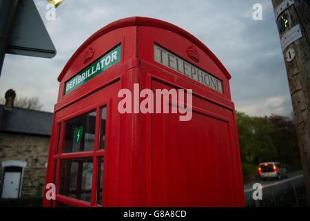 Eine helle rote Telefonzelle umgewandelt zu Haus und Notfall-Defibrillator bei Herzinfarkten, am Straßenrand in Cwrt Dorf, Snowdonia-Nationalpark, Gwynedd, Nord Wales UK Stockfoto