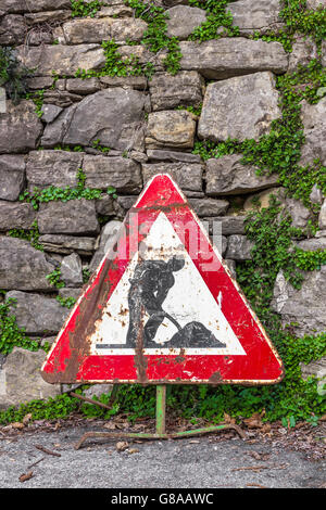 Alten unfertigen Straßenschild mit Ziegelmauer auf Hintergrund. Stockfoto