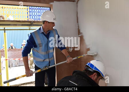 Der Duke of Cambridge malt eine Wand während eines Besuchs des BBC DIY SOS Teams für das Big Build: Veteran's Special in einer Straße in Manchester. Stockfoto