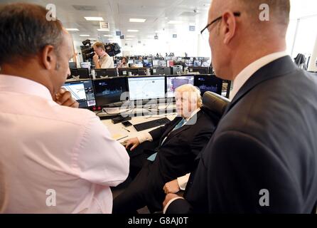 Der Bürgermeister von London, Boris Johnson (rechts), spricht mit den Mitarbeitern während eines Besuchs im TFL Traffic Control Center in Southwark, wo er erweiterte Pläne für den Verkehrskrieg enthüllte, um London in Bewegung zu halten. Stockfoto