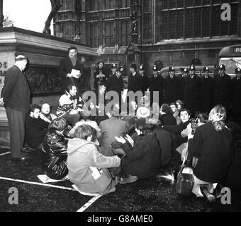 Eine solide Polizeischnur steht über Demonstranten, die auf dem Bürgersteig neben der Coeur de Lion Statue vor dem Houses of Parliament in London sitzen. Dies war eine vom Londoner Komitee von 100 organisierte Demonstration gegen den Krieg in Vietnam. Obwohl es beabsichtigt war, die Sitzung im Unterhaus abzuhalten, schafften es nur drei Personen, einzusteigen, bevor sie abgeführt wurden. Die Polizei beendete das Hinsetzen schließlich, indem sie eine Reihe von Demonstranten in einen Lieferwagen trug. Eine Reihe von Menschen wurden beschuldigt, die Autobahn blockiert zu haben. Stockfoto