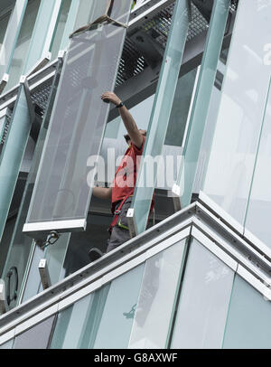 Arbeiter, die Montage externer Glas Lamellen an Energie effiziente neue Bürogebäude in Spanien Stockfoto
