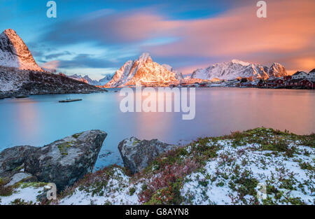 Der rosa Himmel bei Sonnenaufgang beleuchtet Reine Dorf mit seinen kalten See und der schneebedeckten Gipfeln Lofoten Inseln Norwegen Nordeuropa Stockfoto