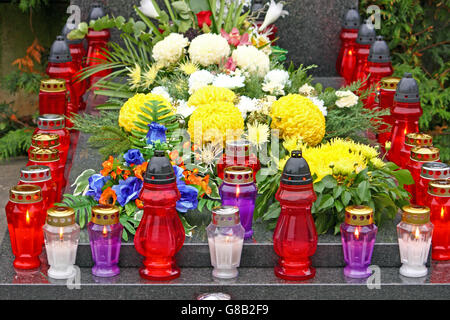 Blumen und Kerzen, die auf dem Grab, Laterne leuchtet Stockfoto