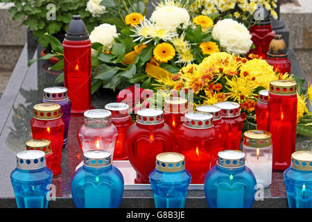 Blumen und Kerzen, die auf dem Grab, Laterne leuchtet Stockfoto