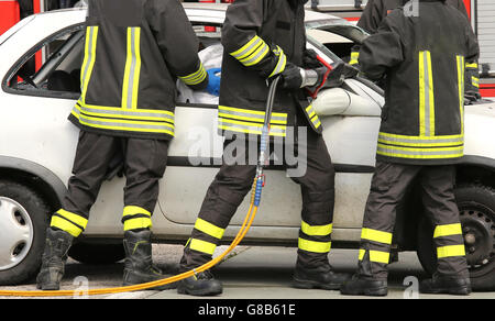 tapfere Feuerwehrmänner entlasten einen verletzten nach einem Unfall während einer Übung im Feuerwehrhaus Stockfoto