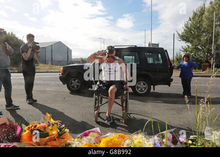 Der ehemalige Polizist Swasie Turner MBE (Mitte), nachdem er Blumen am Tatort in Wallasey, Merseyside, in der Nähe von PC David Phillips, niedergemäht und von einem Fahrer in einem gestohlenen Auto getötet wurde, platziert hatte, da ihm eine Gedenkstätte zur Verfügung gestellt wurde. Stockfoto