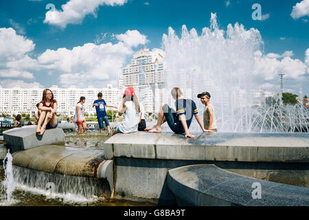 Minsk, Belarus - 2. Juni 2015: Junge Menschen sitzen, die Ruhe in der Nähe von Brunnen In der Sommerhitze. Nemiga Ditrict In Minsk, Weißrussland Stockfoto