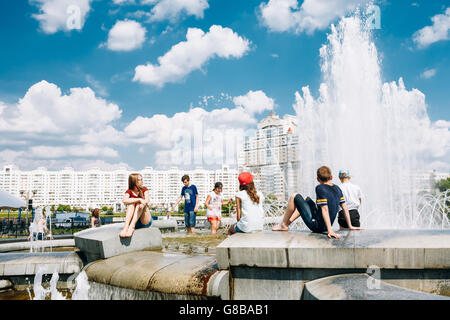 Minsk, Belarus - 2. Juni 2015: Junge Menschen sitzen, die Ruhe in der Nähe von Brunnen In der Sommerhitze. Nemiga Ditrict In Minsk, Weißrussland Stockfoto