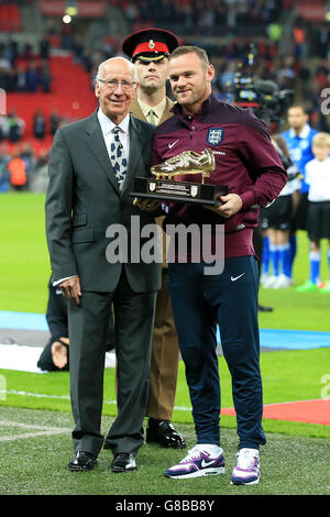 Sir Bobby Charlton überreicht dem englischen Wayne Rooney einen goldenen Stiefel, um zu gedenken, dass er vor dem UEFA-Europameisterschaftsspiel im Wembley Stadium in London zum allzeit führenden Torschützenkönig seines Landes wurde. Stockfoto