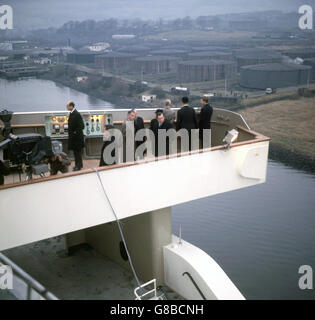 Prinz Charles (ganz rechts) auf der Brücke der QEII (Queen Elizabeth II) Cunard Liner während ihrer ersten Reise, den Fluss Clyde hinunter vom Ausbaubecken bei Clydebank zum Trockendock bei Greenock, nahe Glasgow. Stockfoto