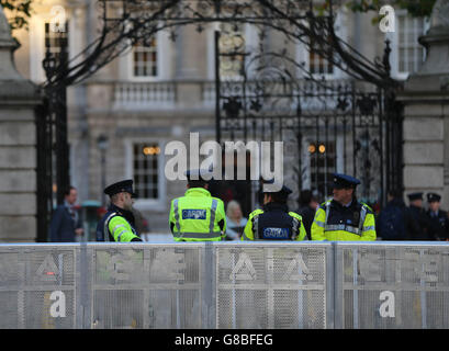 Garda-Offiziere stehen vor dem Leinster House in Dublin an Stahlbarrieren, aber es gab keine Proteste, als Minister für öffentliche Ausgaben und Reform Brendan Howlin und Finanzminister Michael Noonan den irischen Haushalt übergaben. Stockfoto