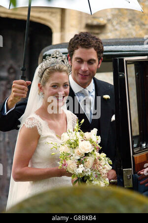 Hugh Van Cutsem hält nach ihrer Hochzeit eine Umberella für seine neue Braut Rose Astor. Stockfoto