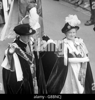 In blauen Samtmänteln und Hüten, die mit Straußenfedern geschmückt sind, geht Queen Elizabeth, die Königin Mutter, in Prozession mit dem Herzog von Norfolk in Windsor Castle. Sie sollen an dem Orden des Kleiderdienstes in der St. George's Chapel teilnehmen. Stockfoto