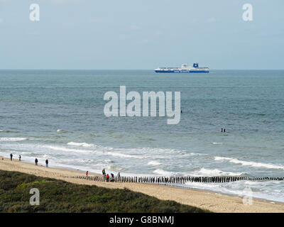 Der Strand von Domburg, Zeeland, Niederlande mit einem Container-Schiff Segeln entlang der Küste Stockfoto