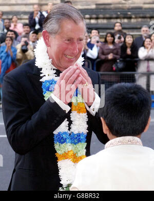 Der Prinz von Wales dankt einem Jungen für die Girlanden, die er bei ihrer Ankunft um den Hals gelegt hat. Der Prinz und die Herzogin von Cornwall wurden mit den Girlanden geschmückt, als sie die Bräuche eines traditionellen indischen Willkommensgruß annahmen, als sie ankamen, um den IMAX-Film Mystic India zu sehen. Stockfoto
