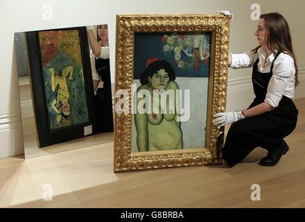 Sothebys Assistent zeigt Picassos „La Gommeuse“, dessen Rückseite sich während einer Pressevorschau für den New Yorker Impressionisten und den Modern Art Evening Sale im Zentrum von London in einem Spiegel widerspiegelt. Stockfoto