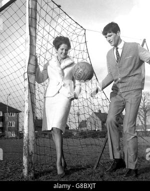 Peter Dolby von Shrewsbury Town übt mit einem Fußball, während seine 22-jährige Schönheitskönigin Pat aufschaut. Morgen trifft das Shropshire-Team in einem fünften Gleichstand auf der Stamford Bridge die FA Cup-Favoriten Chelsea. Pat ist seit vier Saisons Vizemeister beim National Butlin's Holiday Princess Contest. Stockfoto