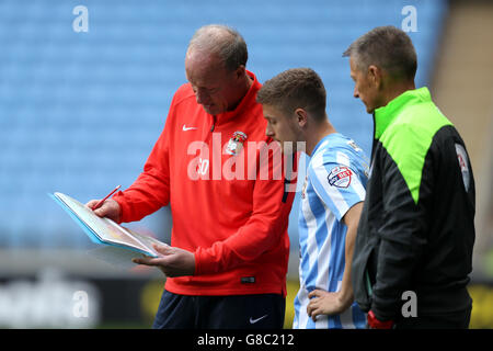 Soccer - Sky Bet League One - Coventry City / Blackpool - Ricoh Arena. Steve Ogrizovic, Torwarttrainer von Coventry City, gibt Anweisungen an Aaron Phillips von Coventry City (Mitte) Stockfoto