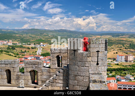 Portugal, Tras-os-Montes: Frauen mit roten Hut und roten Kleid auf einem Aussichtsturm von der mittelalterlichen Burg von Braganca Stockfoto