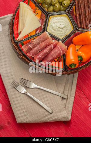 Korb mit spanischen Tapas auf einem rustikalen Holztisch rot Stockfoto