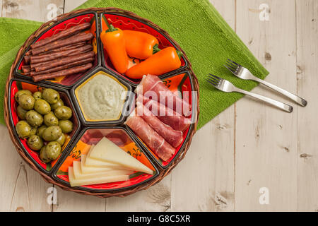 Korb mit spanischen Tapas auf einem rustikalen Holztisch weiß Stockfoto