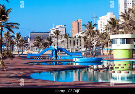 Blau schwimmen Freizeitbecken Bereich und Palmen Bäume gegen Strand Frontstadt Skyline in Durban in Südafrika Stockfoto