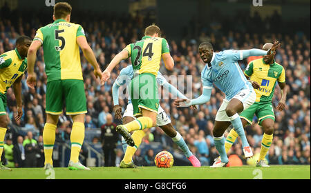 Die Yaya Toure von Manchester City (zweite rechts) kämpft mit Ryan Bennett von Norwich City während des Barclays Premier League-Spiels im Etihad Stadium in Manchester um den Ball. Stockfoto