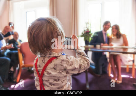 Kind auf dem Standesamt ein frisch vermählte Paar zu fotografieren Stockfoto