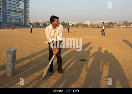 Straßenkinder und Erwachsene spielen Cricket im B.K.C. Bandra Kurla Complex, Bandra East, Mumbai, Maharashtra, Indien Stockfoto