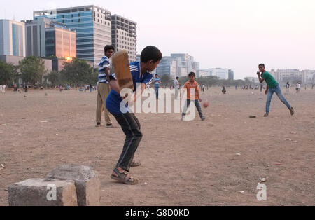 Straßenkinder und Erwachsene spielen Cricket im B.K.C. Bandra Kurla Complex, Bandra East, Mumbai, Maharashtra, Indien Stockfoto