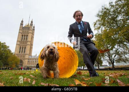 Hugo Swire MP mit Cockapoo Rocco bei der Westminster Dog of the Year 2015 Show in den Victoria Tower Gardens, Westminster, London. Stockfoto