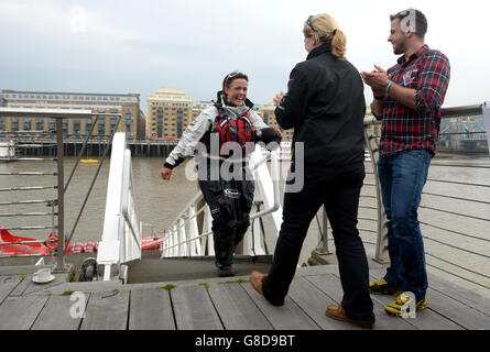 Die britische Abenteurerin Sarah Ouen (links) läuft die Gangway hinauf, um die Verlobte Lucy Allen (Mitte) und Bruder Matt Ouen (rechts) zu begrüßen, nachdem sie unter der Tower Bridge mit dem Kajak gefahren ist, um ihr viereinhalb Jahre lang London2London zu absolvieren: Über die Weltexpedition, die sie 25,000 Meilen um die Welt radeln, Kajak fahren und rudern sah. Stockfoto