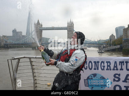 Die britische Abenteurerin Sarah Ouen sprüht Champagner, um nach dem Kajakfahren unter der Tower Bridge zu feiern, um ihre viereinhalb Jahre lange London2London: Via the World-Expedition abzuschließen, die ihre 25,000 Meilen um die Welt radeln, Kajak fahren und rudern sah. Stockfoto