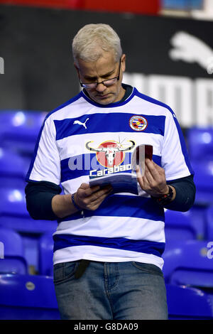 Fußball - Sky Bet Championship - Reading / Huddersfield Town - Madejski Stadium. Ein Reading-Fan liest das Spieltagsprogramm in den Ständen vor dem Spiel Stockfoto