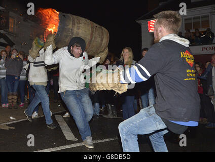 Erwachsene aus dem Dorf Ottery St Mary in Devonshire tragen das traditionelle Tar Barrel in der Bonfire Night durch die Straßen des Dorfes. Stockfoto