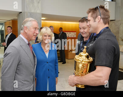 Der Prinz von Wales und die Herzogin von Cornwall sprechen mit Neuseeland All Blacks Captain Richie McCaw (rechts), als er die Rugby World Cup Trophy hält, und Coach Steve Hansen (zweiter rechts), vor einer Siegesparade um die Straßen von Wellington in Neuseeland. Stockfoto