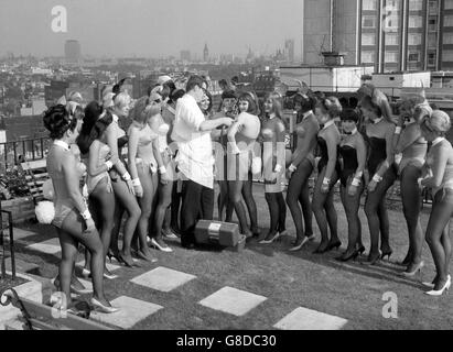 Die Bunny Girls stellen sich für den glücklichen Medizinmann Mike Steel auf, der sie im Playboy Club in Park Lane, London, gegen Grippe geimpft hat. Stockfoto