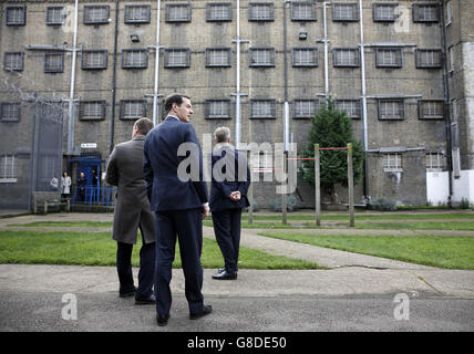 Schatzkanzler George Osborne (Mitte) und Justizminister Michael Gove (rechts) werden um den Übungshof vor dem 'A' Flügel des HM Prison Brixton im Süden Londons gezeigt. Stockfoto