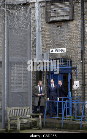 Schatzkanzler George Osborne (Mitte) und Justizminister Michael Gove (rechts) werden um den Übungshof vor dem 'A' Flügel des HM Prison Brixton im Süden Londons gezeigt. Stockfoto