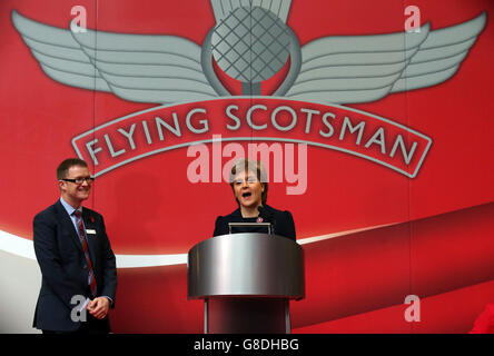 Die erste Ministerin Nicola Sturgeon hält eine Rede, die David Horne, MD von Virgin Trains East Coast, neben dem Virgin Train Flying Scotsman ansieht, während seine neue Lackierung bei einer Zeremonie am Bahnhof Edinburgh Waverley enthüllt wird. Stockfoto