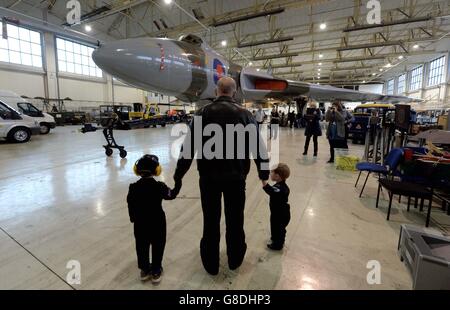 Air Electronics Officer Phil Davies mit seinen beiden Enkeln Max Ashmore, 2, (rechts) und Oscar Marriott, 4, schaut euch Vulcan XH558 in einem Hanger vor seinem geplanten Endflug am Robin Hood Airport von Doncaster an. Stockfoto