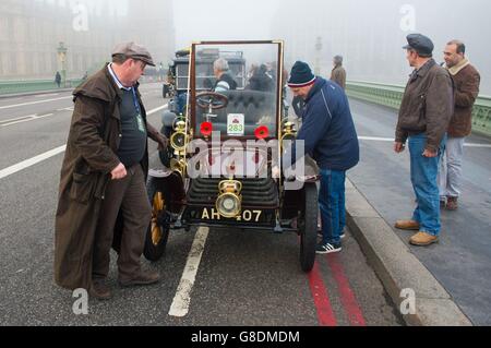 Die Teilnehmer des Veteran Car Run von Bonhams London nach Brighton versuchen, ein defektes Auto auf der Westminster Bridge, London, zu reparieren. Stockfoto