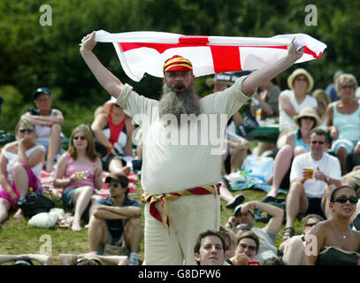 Ein Tennisfan, der als der legendäre englische Batsman W. G. Grace gekleidet ist, zeigt seine Unterstützung für den britischen Tim Henman aus Henman Hill, während die Zuschauer zuschauen. Stockfoto